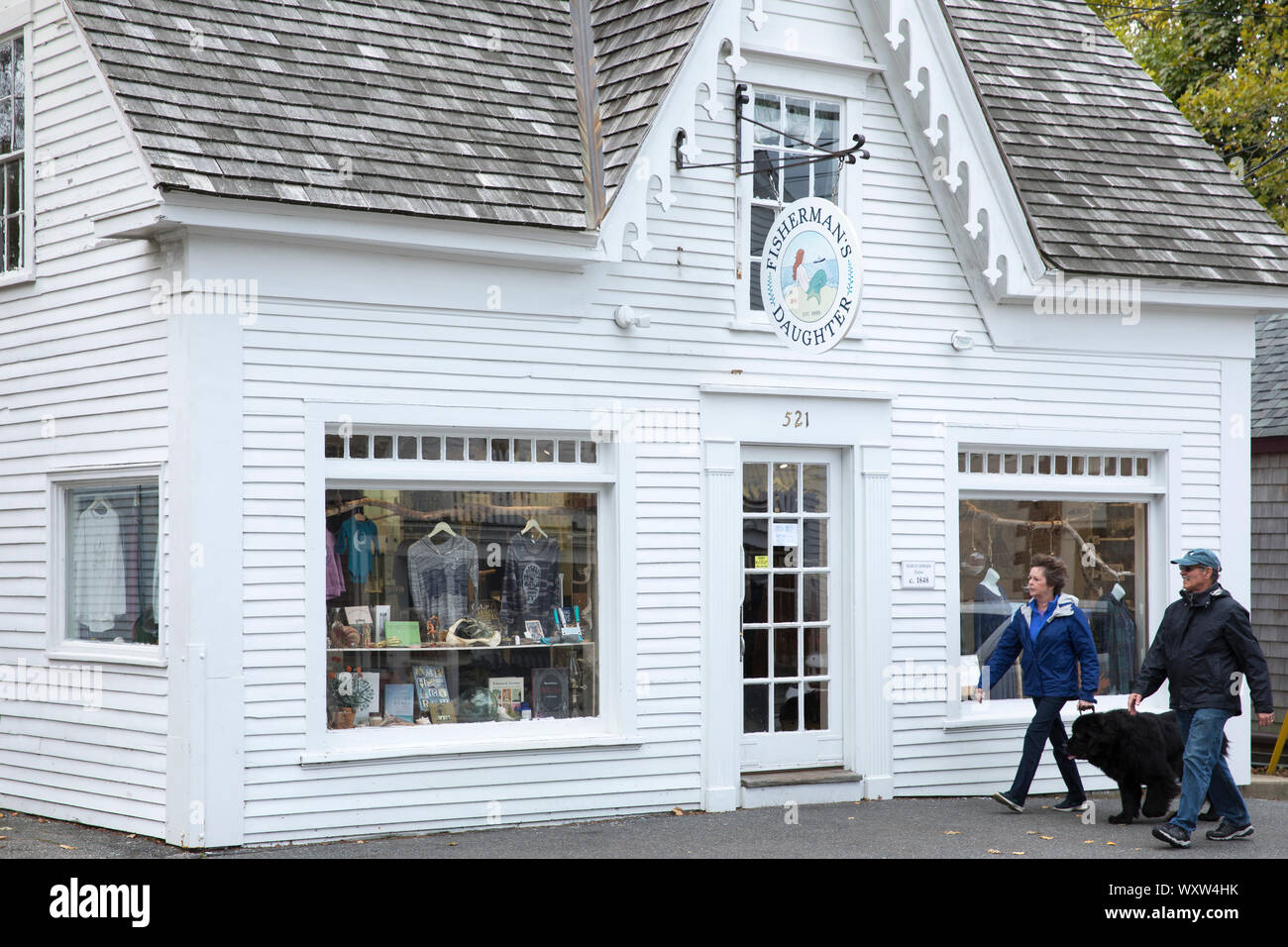 Couple et chien de Terre-Neuve à pied par Fisherman's Daughter deck store dans High Street à Chatham, Cape Cod, New England, USA Banque D'Images