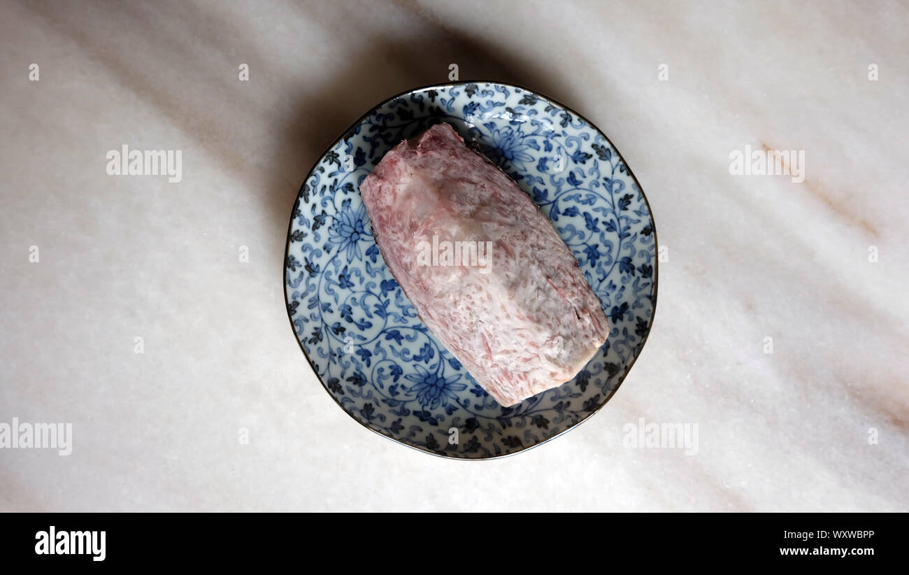 Une grande partie de l'igname pourpre à la vapeur sur une plaque bleue, sur une surface en marbre. Vue d'en haut. Banque D'Images