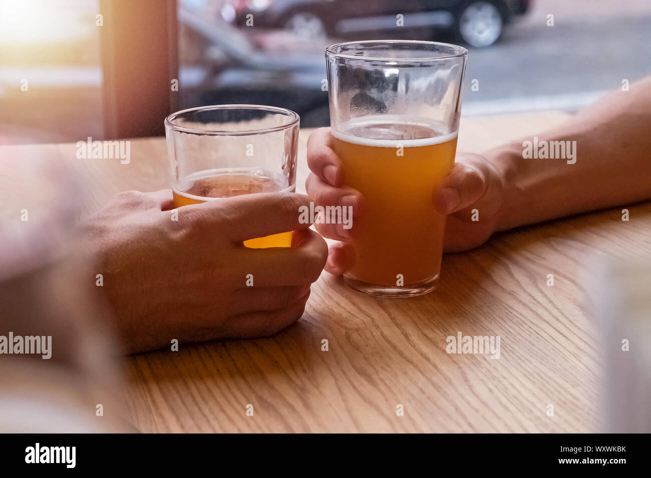 Man's hands holding deux verres de bière ou de trinquer au pub, close-up Banque D'Images