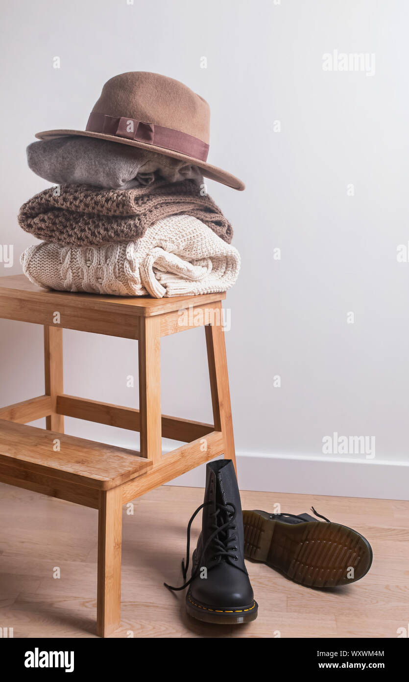 Automne ou hiver armoire. Pile de pulls chauds pliée, chapeau de feutre et des bottes. Banque D'Images