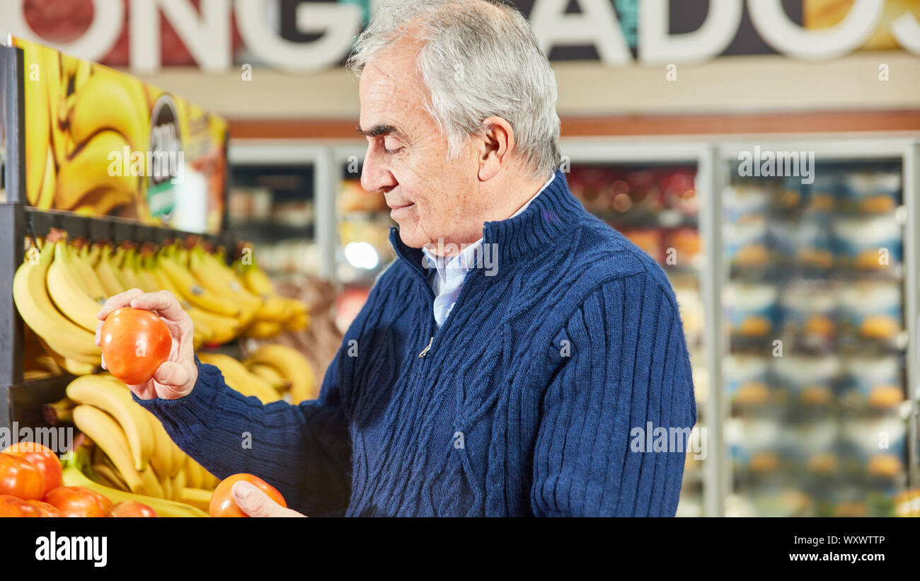 Man en tant que client ou consommateur pendant leurs achats de légumes au supermarché Banque D'Images