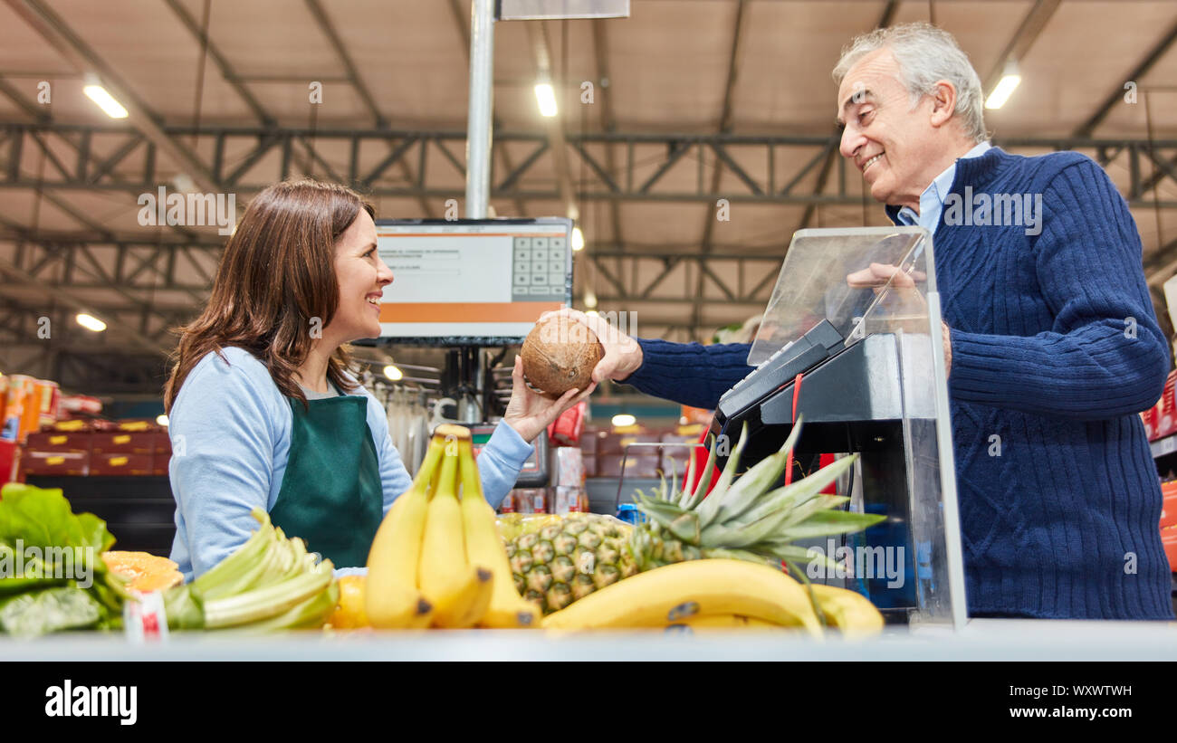 Le client paie les achats de fruits au supermarché au caissier caissier amical Banque D'Images