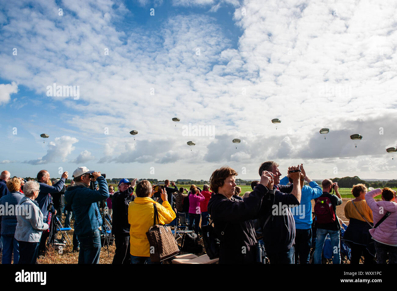 Le public est vu prendre des photos avec leurs téléphones portables pendant le débarquement de les parachutistes.En septembre, c'est exactement il y a 75 ans que les parachutistes de la 82e Division aéroportée a atterri à Groesbeek dans le cadre de l'opération Market Garden. Plus de 1 000 parachutistes sont attendus pour recréer le débarquement de Groesbeek. Pour ces sauts, le 'groupe de parachutistes Holland' original a engagé deux C-47 Dakota de l'Angleterre. Un de ces avions Dakota est appelé Drag 'em Out, a fait plusieurs vols au cours de la Seconde Guerre mondiale, à l'invasion de l'Europe sur la France et l'opération Market Garden aux Pays-Bas. Je Banque D'Images