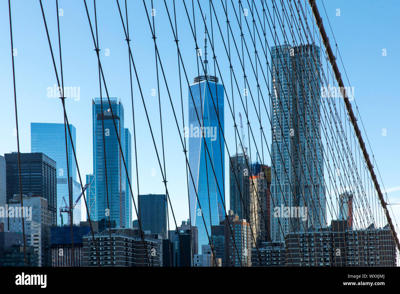 Gratte-ciel de Manhattan vue par l'intermédiaire du fil prend en charge et les câbles du pont de Brooklyn, New York City Banque D'Images