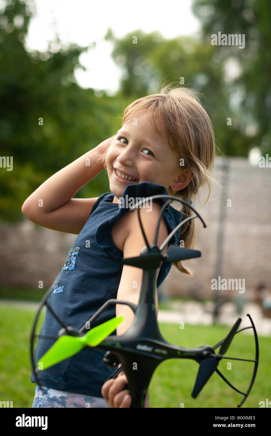 Une petite fille dans le parc tenant un bourdon et l'examen Banque D'Images
