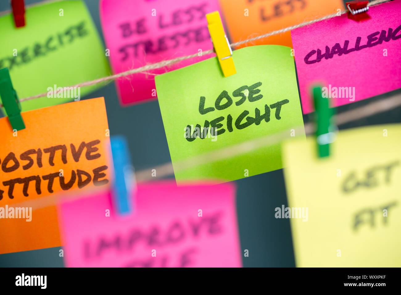 Perdre du poids et d'autres mots de motivation aux modes de vie écrites sur différentes couleurs les notes sont ramenées à la corde Banque D'Images