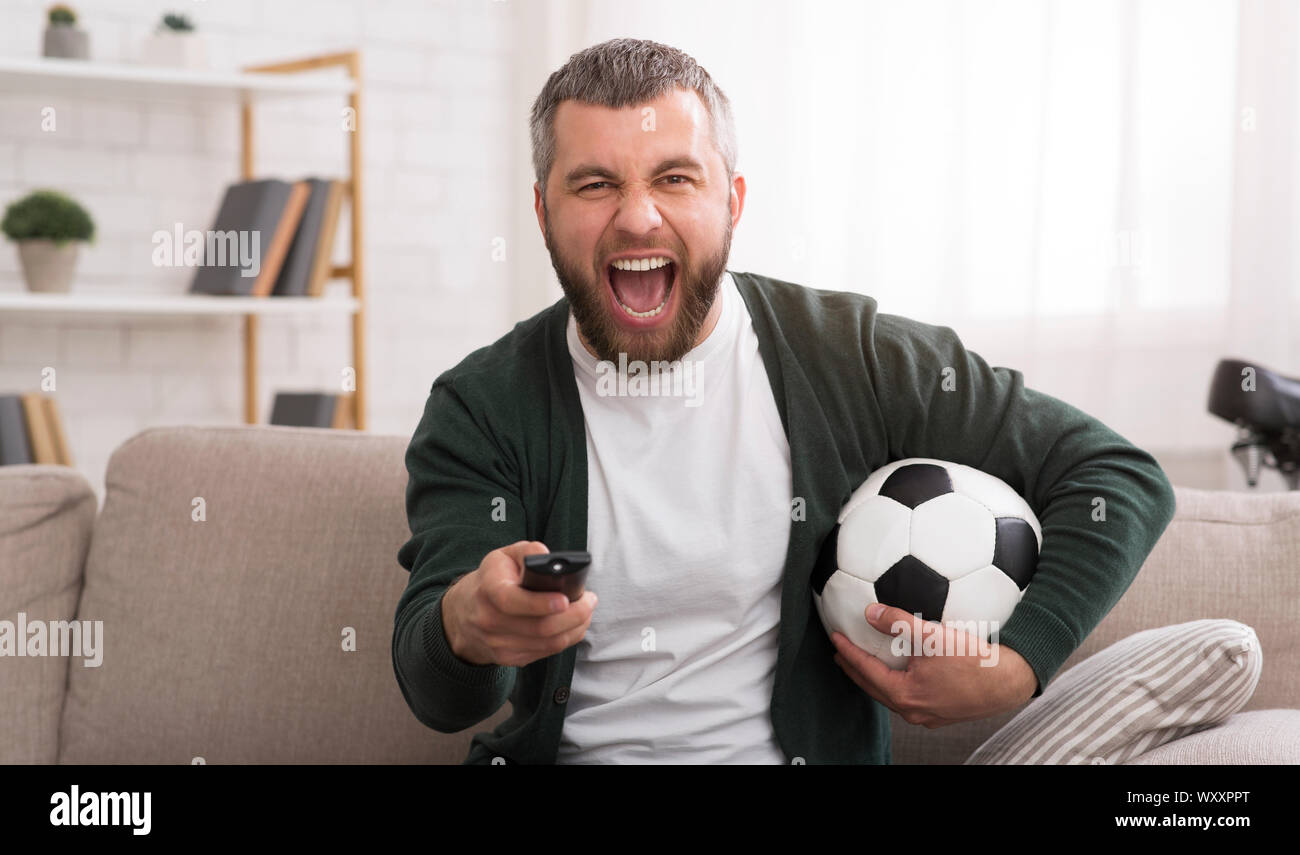 L'homme émotionnel regarder match de football à la télévision Banque D'Images