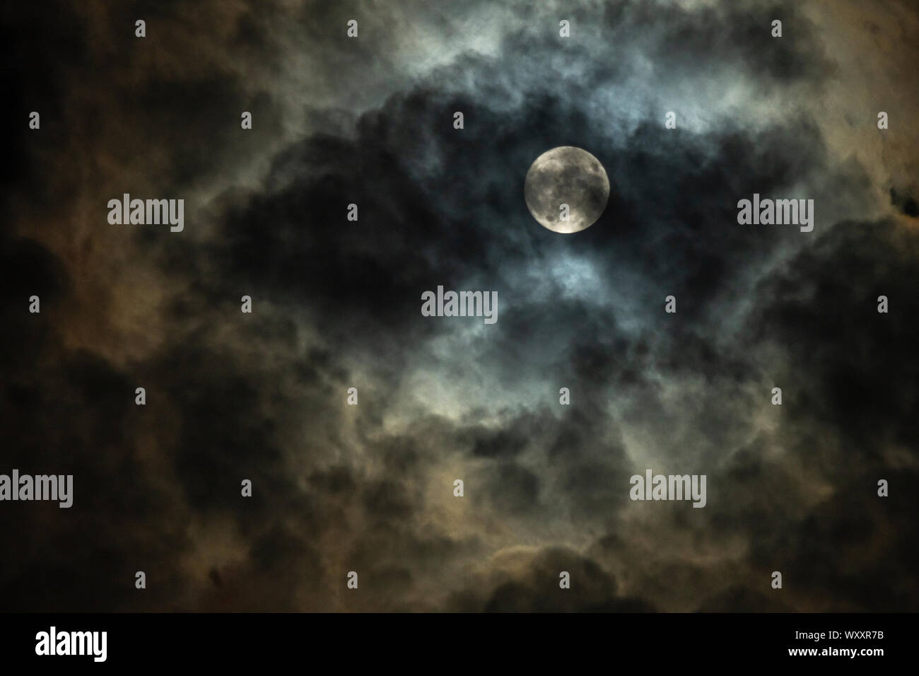 Pleine lune dans le ciel nocturne nuageux Banque D'Images