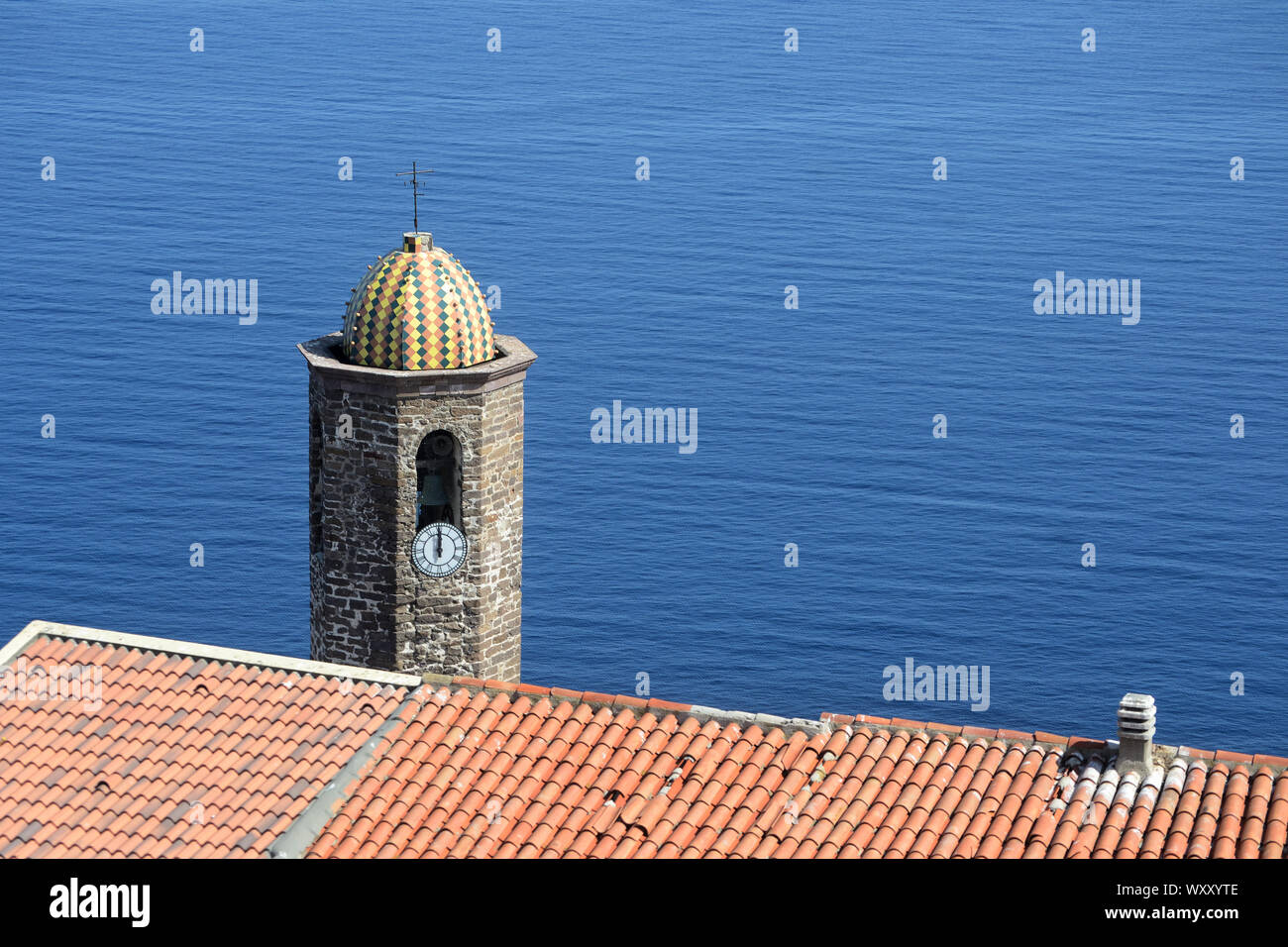 Le clocher de la cathédrale de Sant'Antonio Abate, qui émerge au-delà du toit d'une maison, dans l'ancien village de Castelsardo Banque D'Images