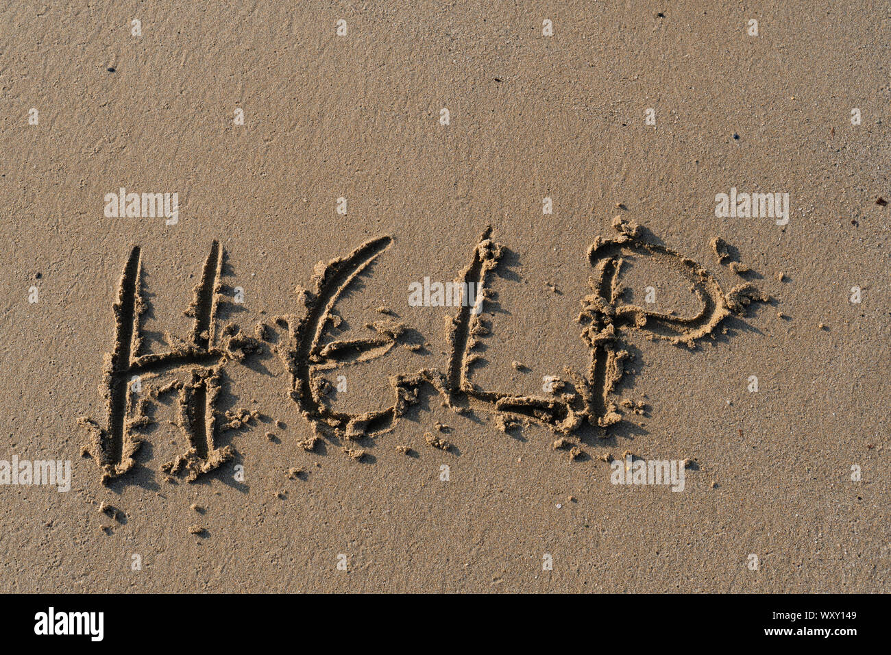 L'aide, écrit comme un message sur le sable Banque D'Images