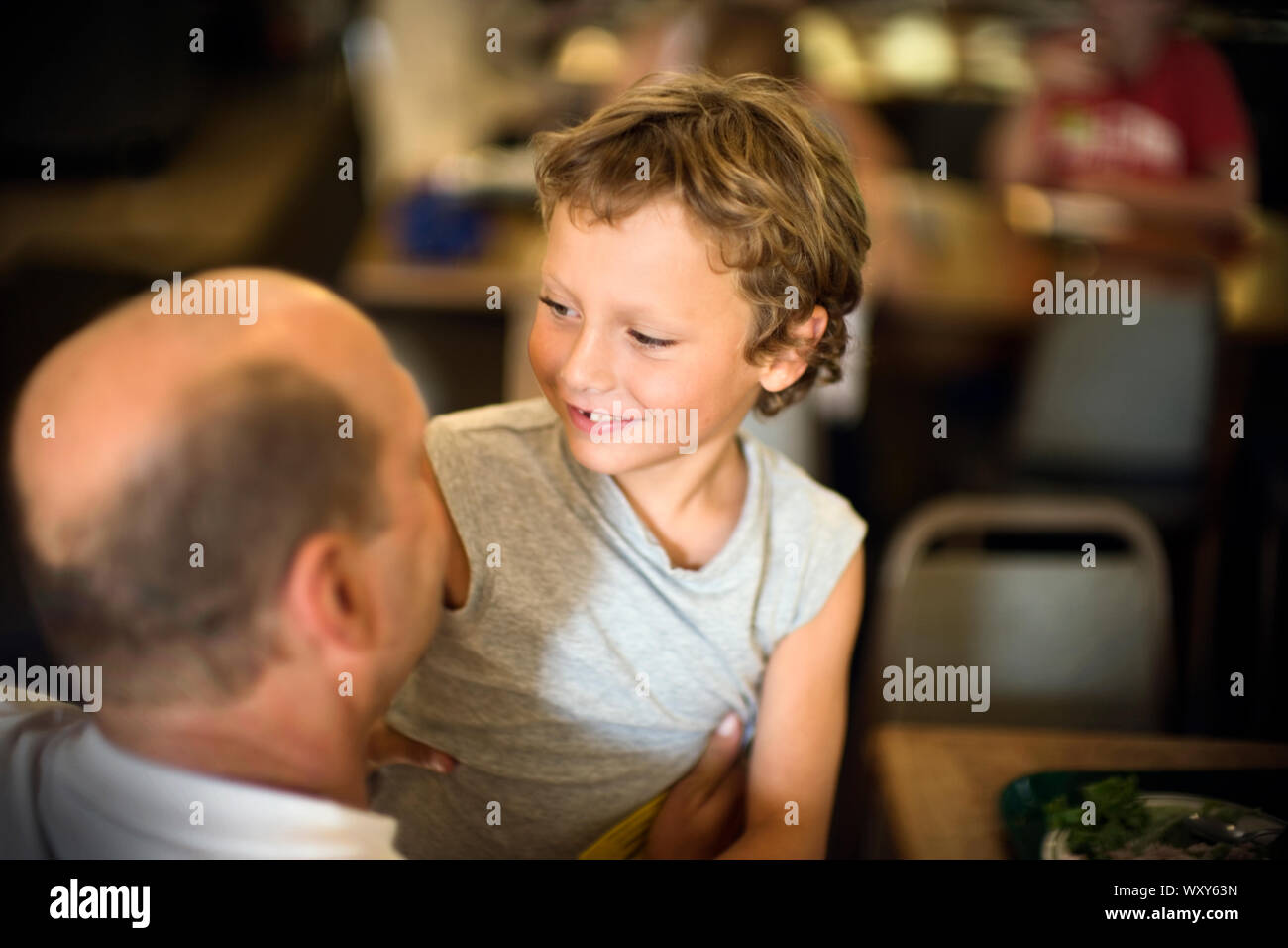 Le père détient son fils alors qu'il était assis dans le restaurant. Banque D'Images