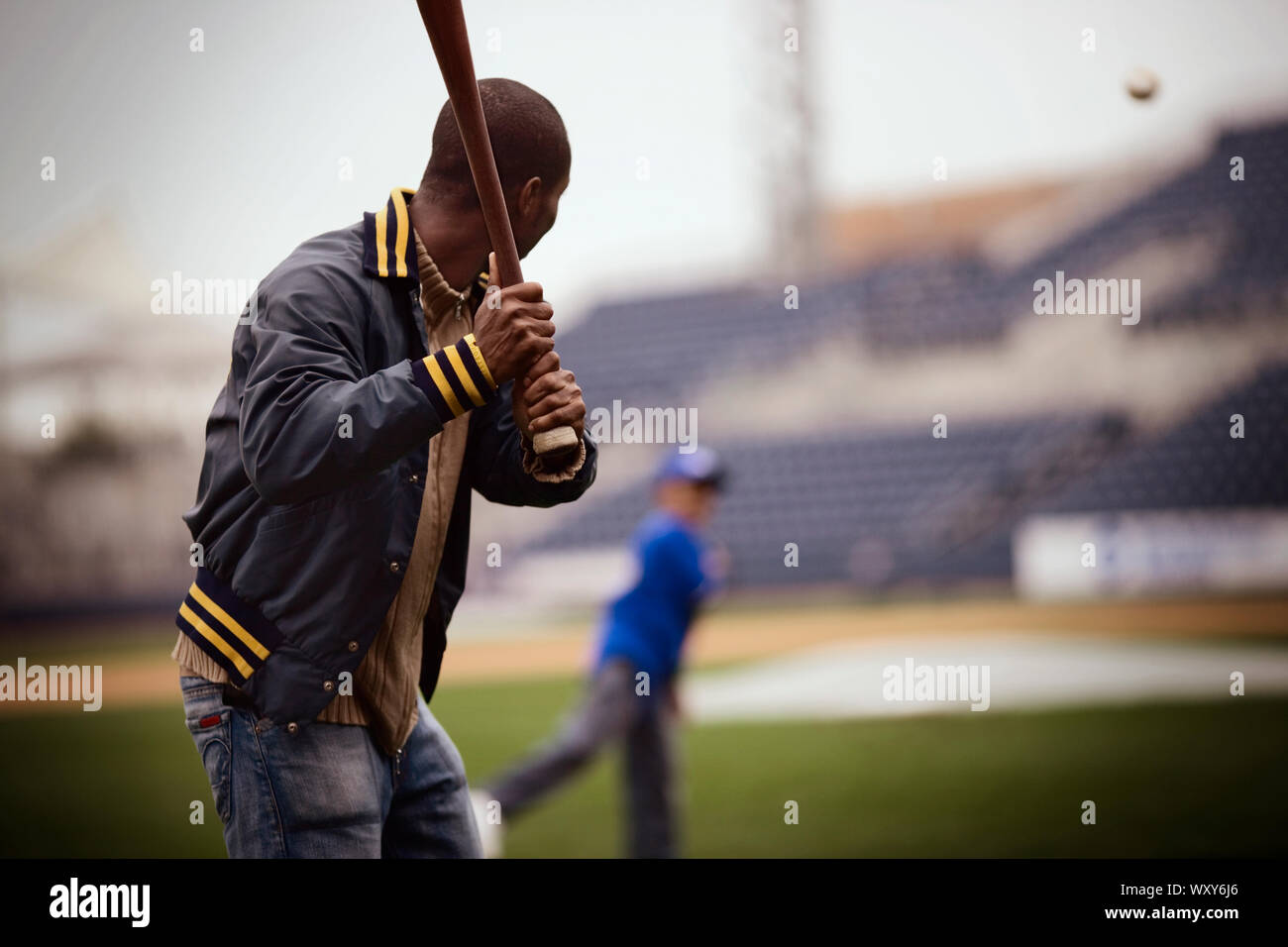 L'homme jouer au baseball avec un petit garçon sur un terrain. Banque D'Images