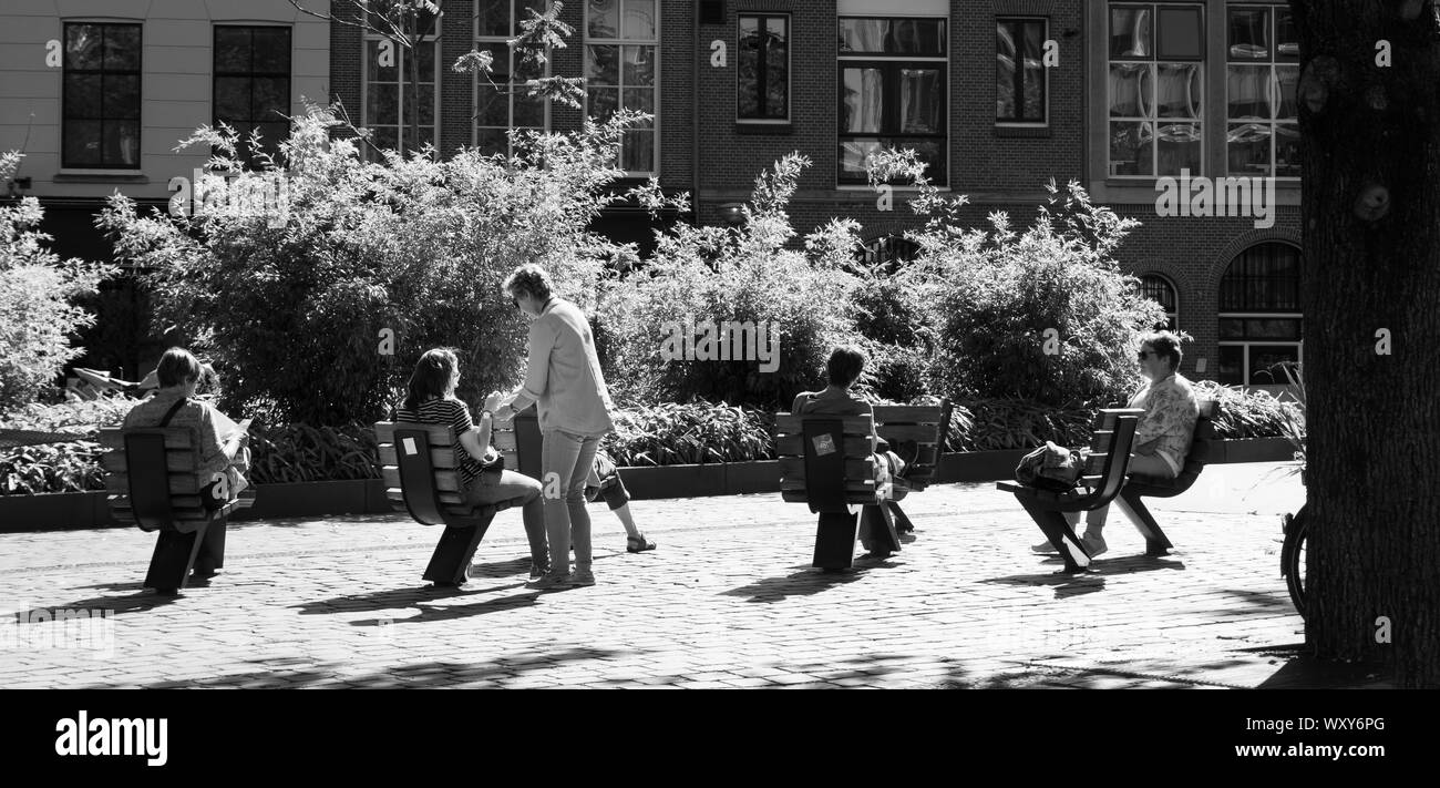Des gens assis sur des chaises à l'extérieur à Rotterdam, ville d'architecture Banque D'Images