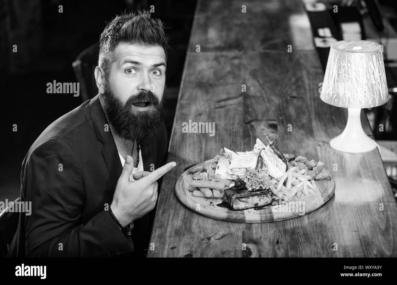 Vous pourrez vous détendre après une dure journée de travail. Woman costume formel s'asseoir à comptoir bar. L'homme a reçu de pommes de terre frites repas avec viande et poisson, lavash. Profitez de repas. Il méritent de délicieux repas. Des calories. Banque D'Images