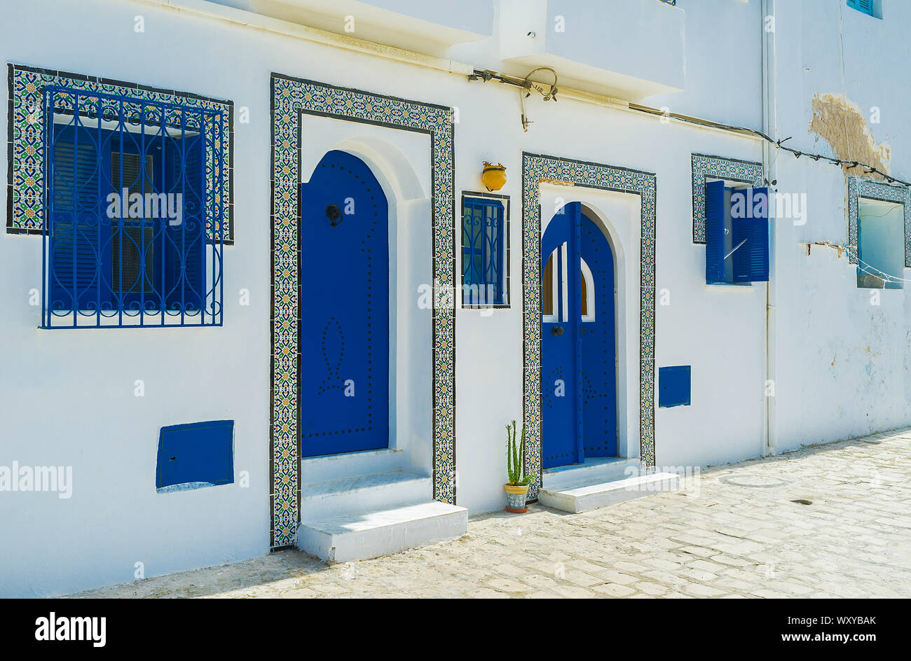 Maison blanche traditionnelle est décorée avec des fenêtre bleu des barbecues, volets et portes, celles qui ont des modèles de rivets, boutons et images vintage carreaux Banque D'Images