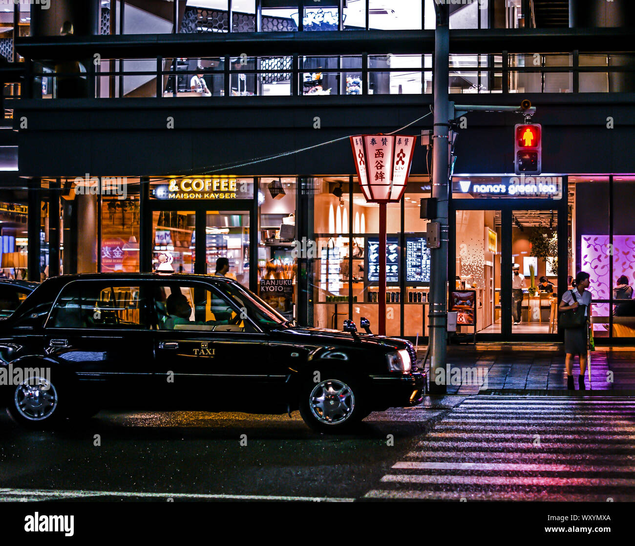 Nuit à Kioto. Vue d'un taxi en face de quelques commerces et un passage pour piétons. Banque D'Images