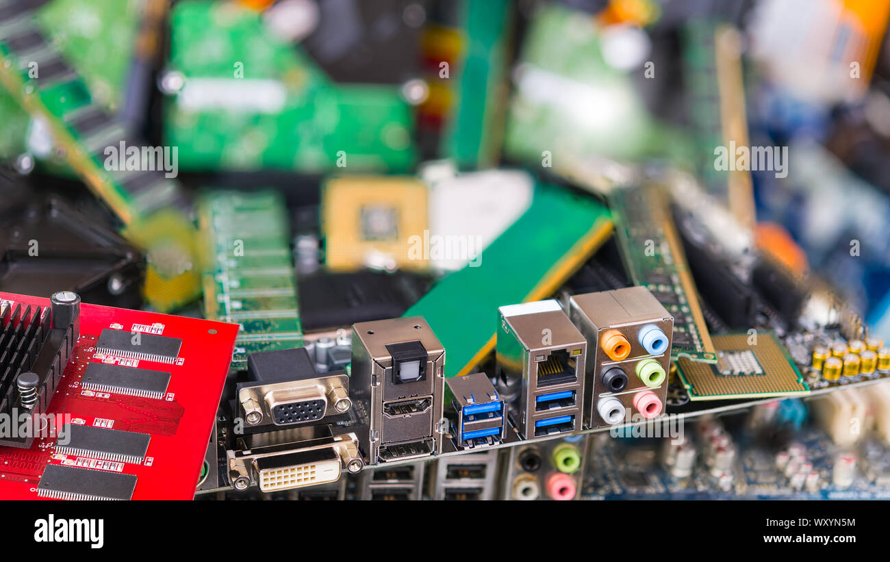 Les connecteurs assortis sur une carte mère d'ordinateur sur un détail e-floue pile de déchets. Utilisés ou périmés des composants électroniques et pièces PC en arrière-plan. Eco. Banque D'Images