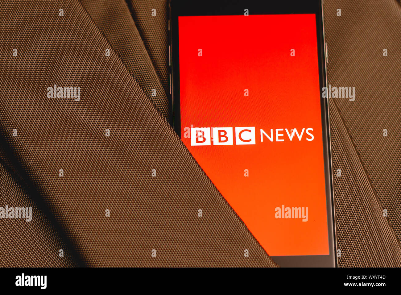 Téléphone noir avec logo des médias Nouvelles de la BBC sur l'écran. Médias d'icône. Texture toile de fond. L'illustration de concept marketing Banque D'Images