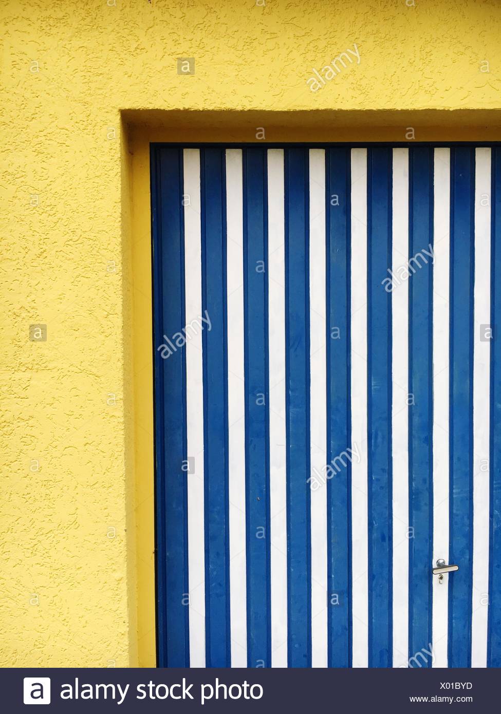 Porte jaune à rayures bleu sur House Banque D'Images