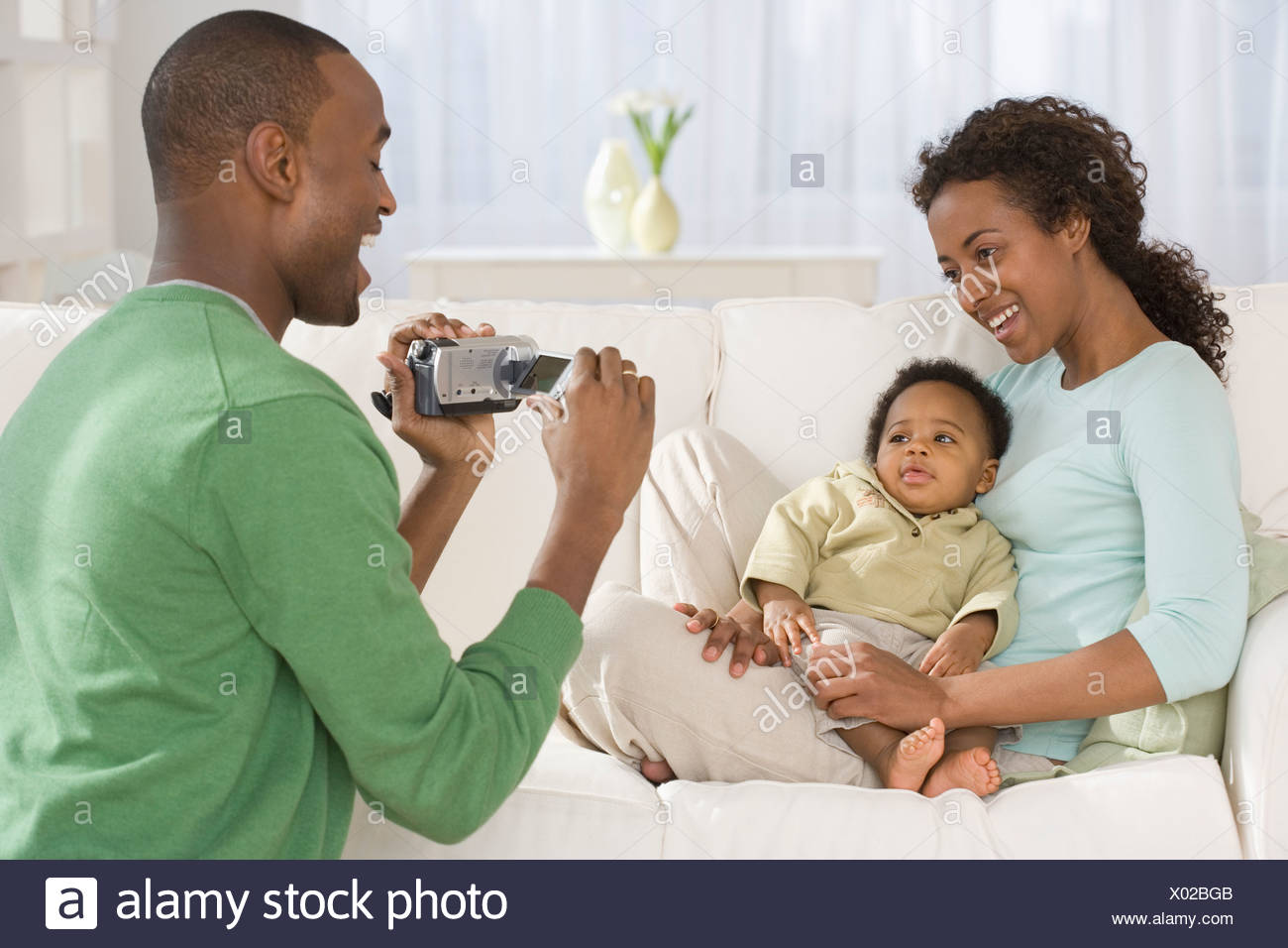 L Enregistrement Video Pere Mere Et Bebe Sur Canape Photo Stock Alamy