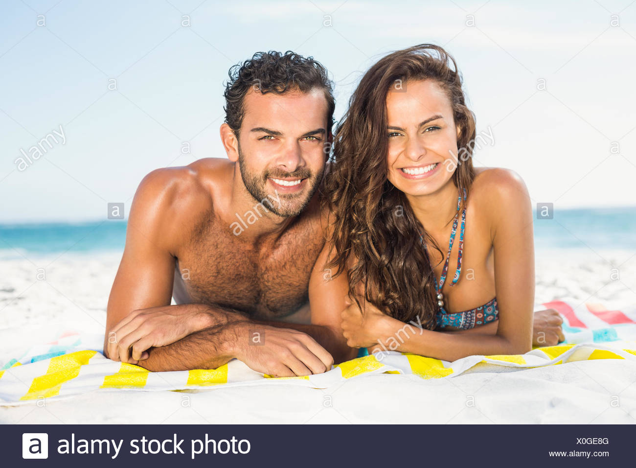 Couple Allongé Sur Une Serviette à La Plage Banque Dimages
