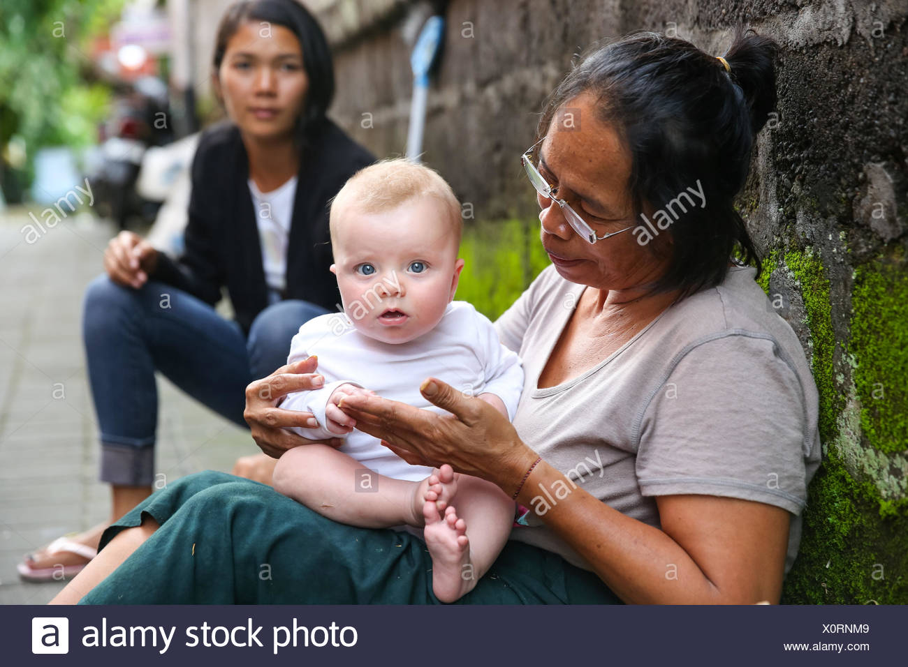 Les Femmes De L Ouest Balinais Jouer Avec Bebe Fille 5 Mois Assis Sur Ses Genoux Le Contact Interculturel Les Locaux De Reunion T Photo Stock Alamy