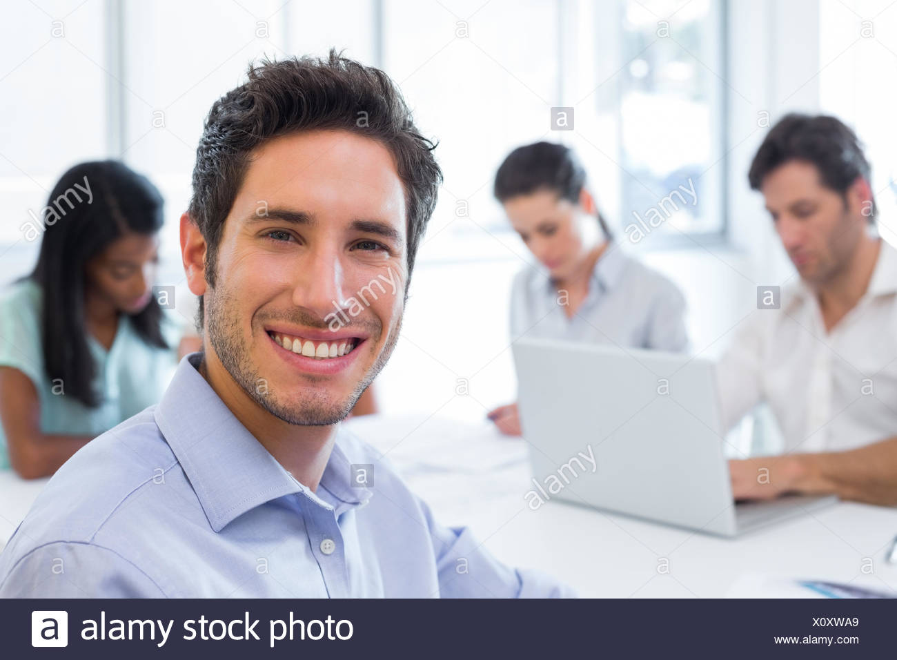 Attractive businessman smiling en milieu de travail Banque D'Images