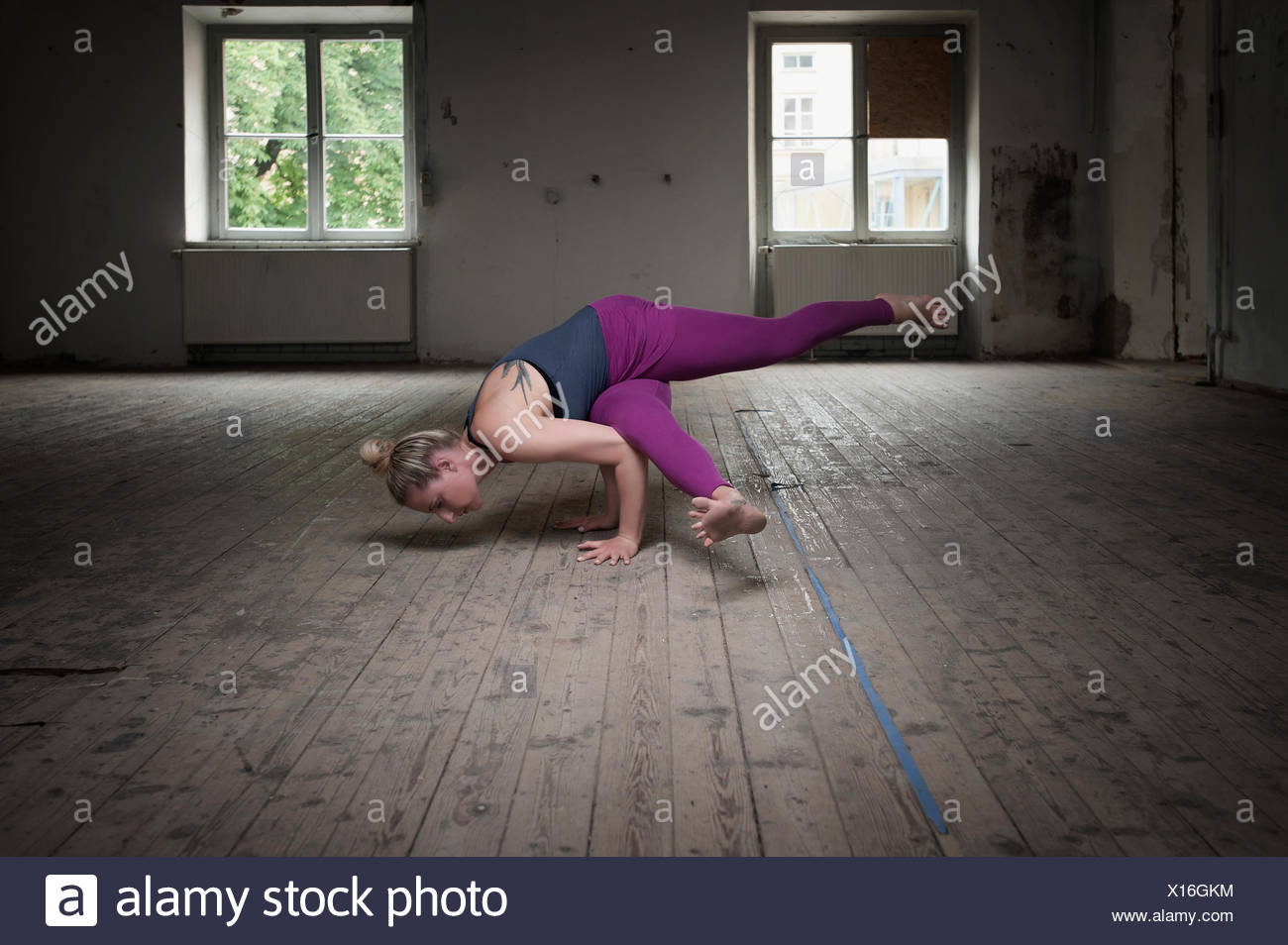 Mid adult woman practicing Eka pada koundinyasana je pose dans un studio de yoga, Munich, Bavière, Allemagne Banque D'Images