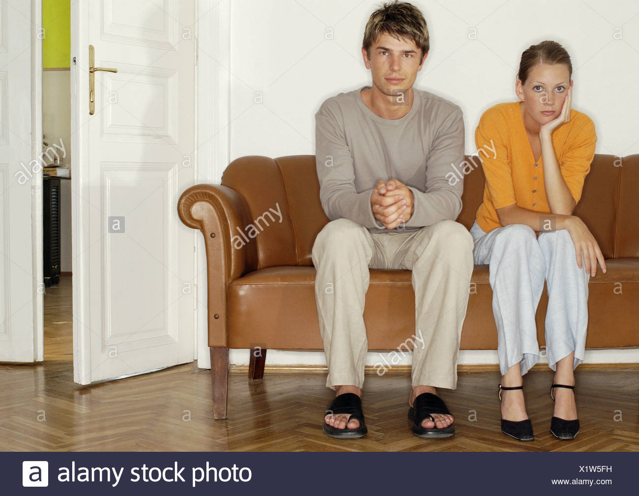 L'homme et la femme assis côte à côte sur le canapé Banque D'Images
