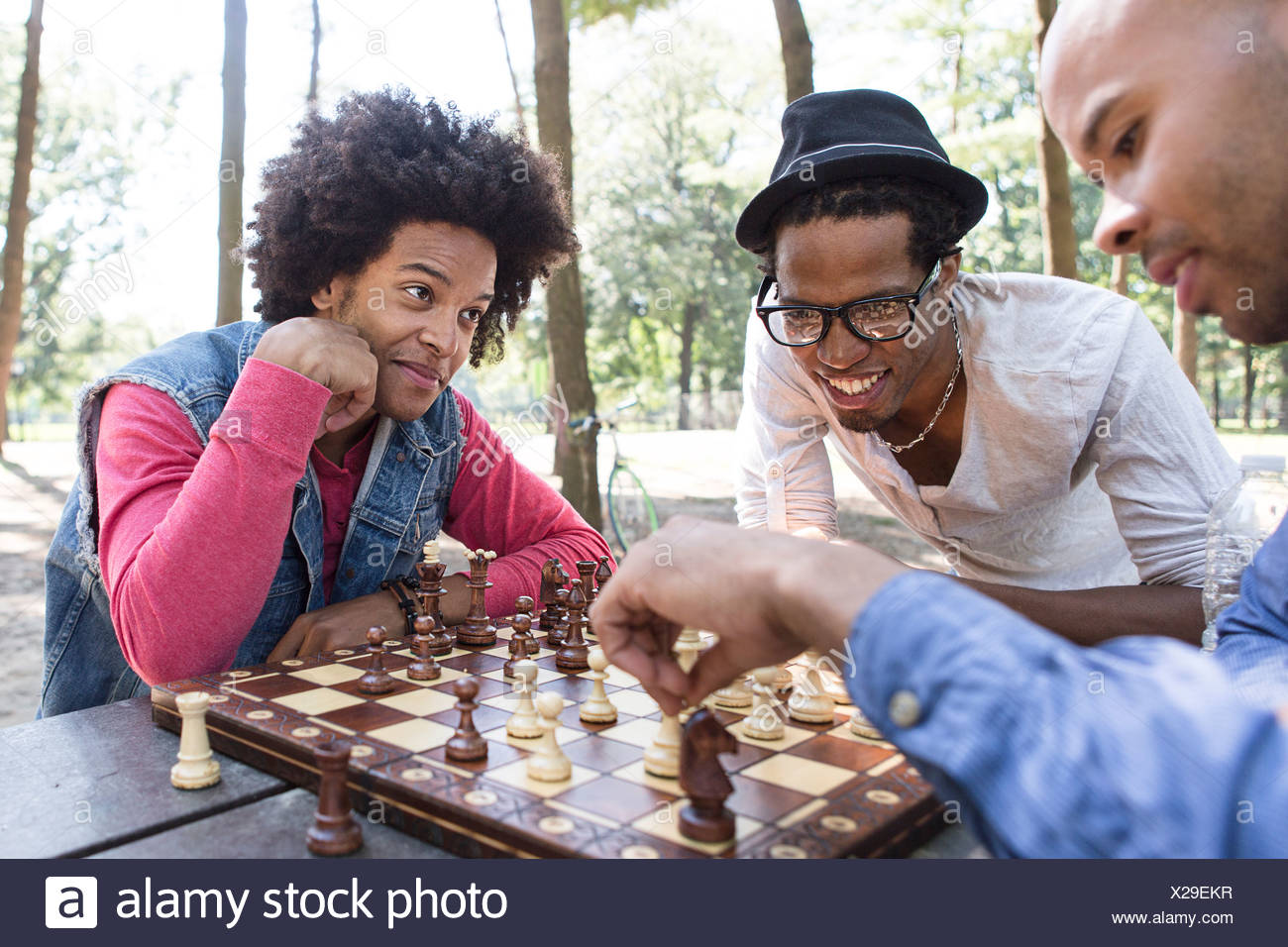 Trois jeunes hommes jouant aux échecs dans le parc Banque D'Images