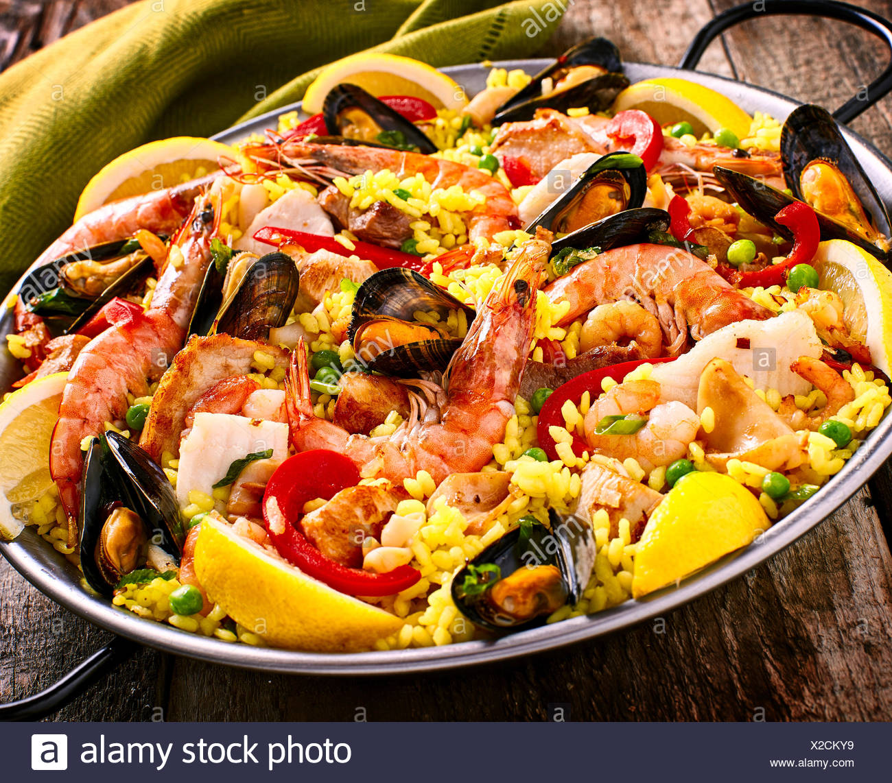 Close Up Of Colorful Fruits De Mer Paella Espagnole Plat De Riz Aux Crevettes Et Coquillages Moules Garnis De Citron Frais Et Servi Dans La Poele Avec Du Linge Vert Serviette Sur