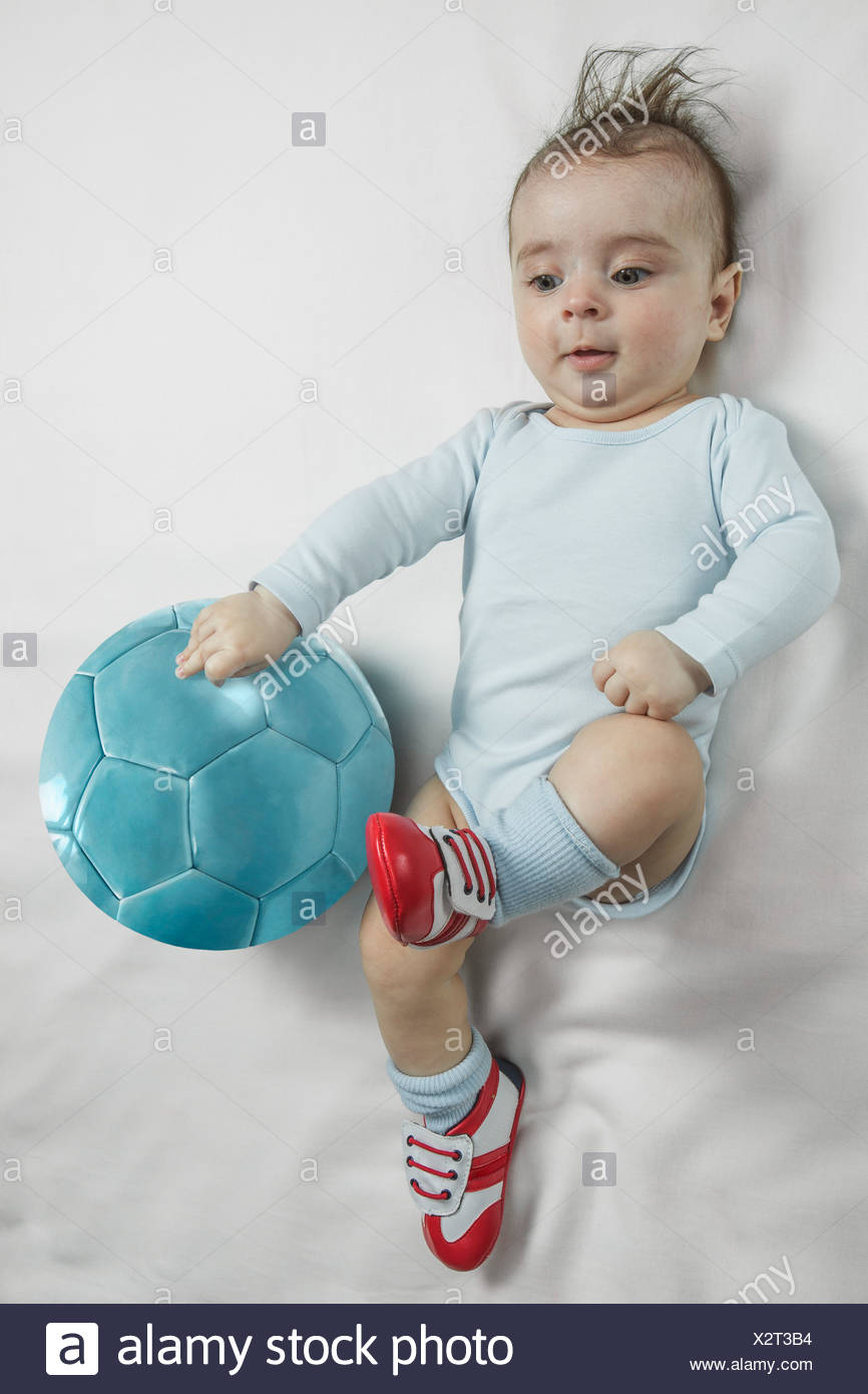 Un Petit Garcon Portant Des Chaussures De Bebe Des Coups Vers Un Ballon De Foot Photo Stock Alamy
