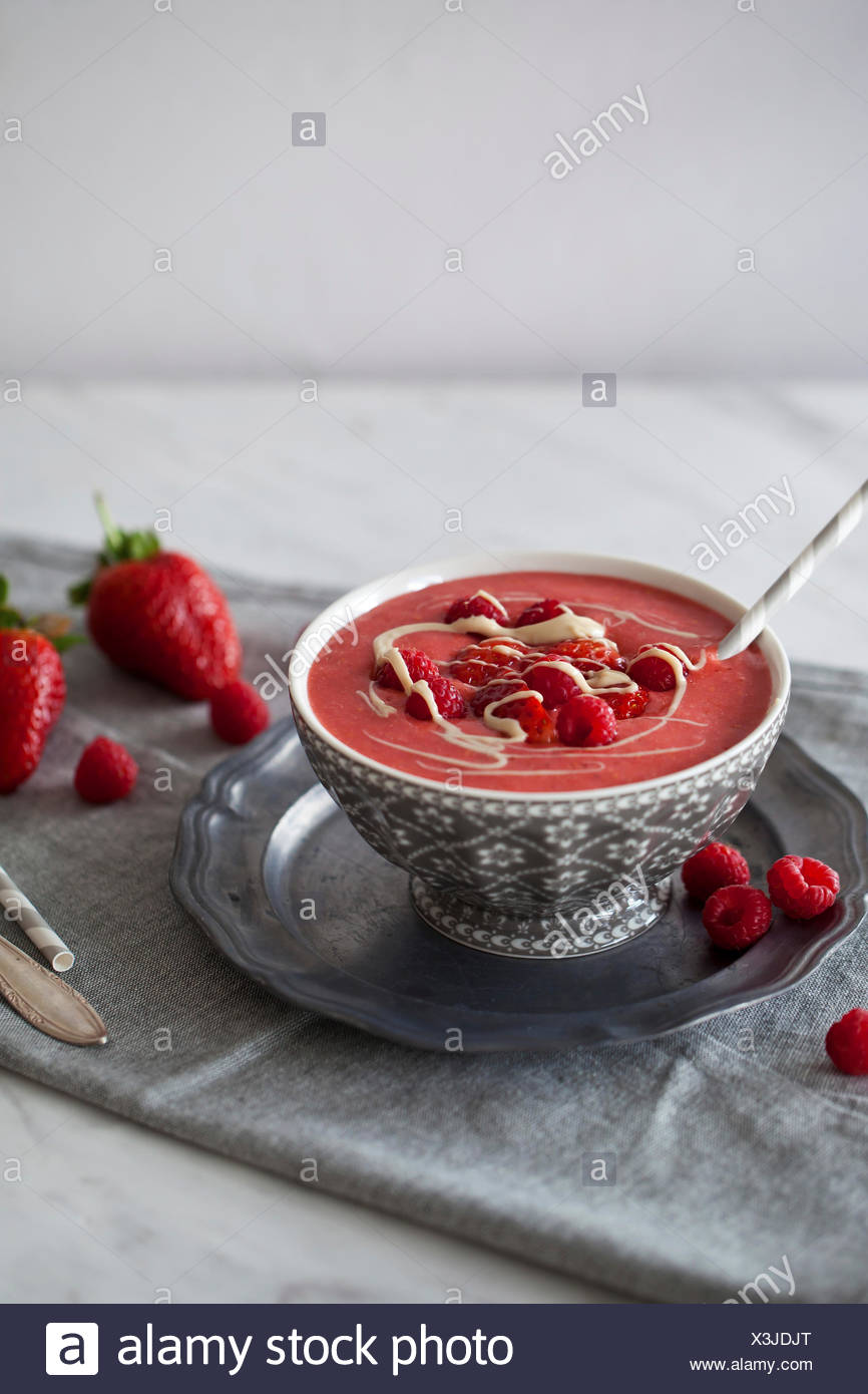 Smoothie aux framboises et fraises rafraîchissante surmontées de baies fraîches et beurre de cajou dans un bol Banque D'Images