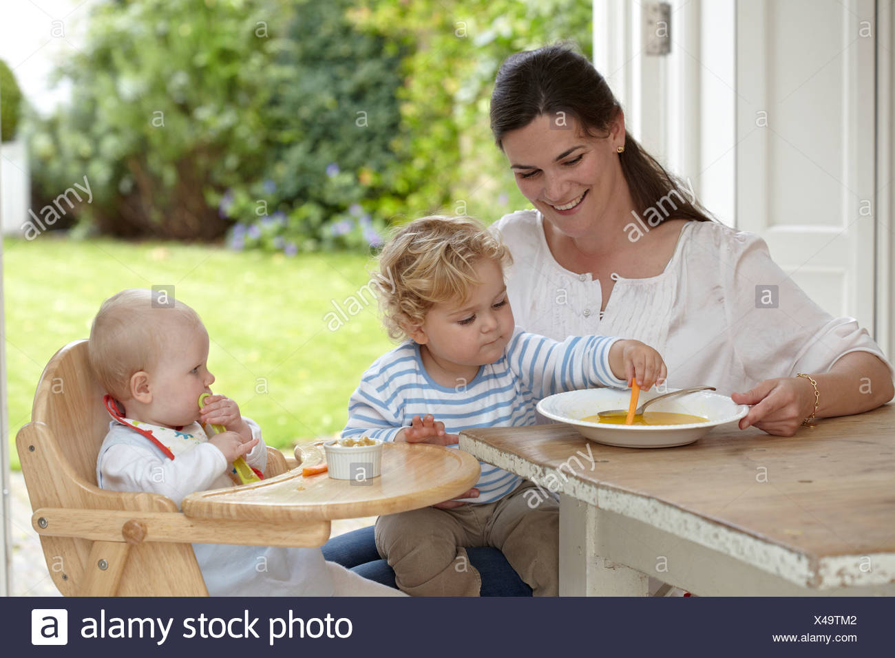 Bebe Garcon 2 Ans 4 Mois Assis Sur Les Genoux De Mere En Fille Bebe Est Assis 9 Mois Dans Une Chaise Haute Au Diner Photo Stock Alamy