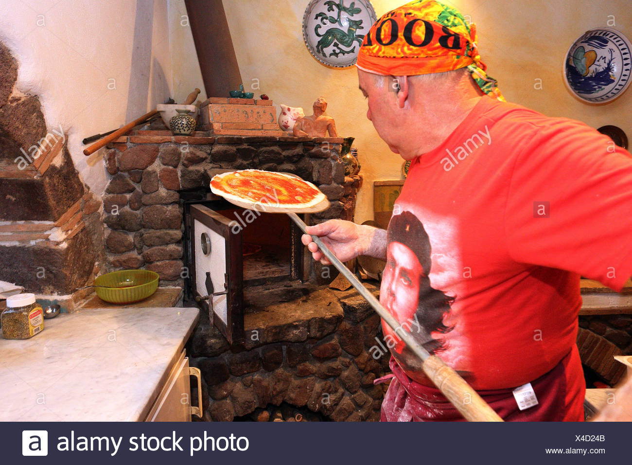 Torre Alfina, Italie, pizza baker pousse une pizza dans un four en pierre Banque D'Images
