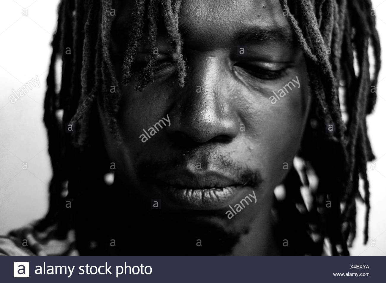 Jeune homme aux cheveux tressés sur fond blanc