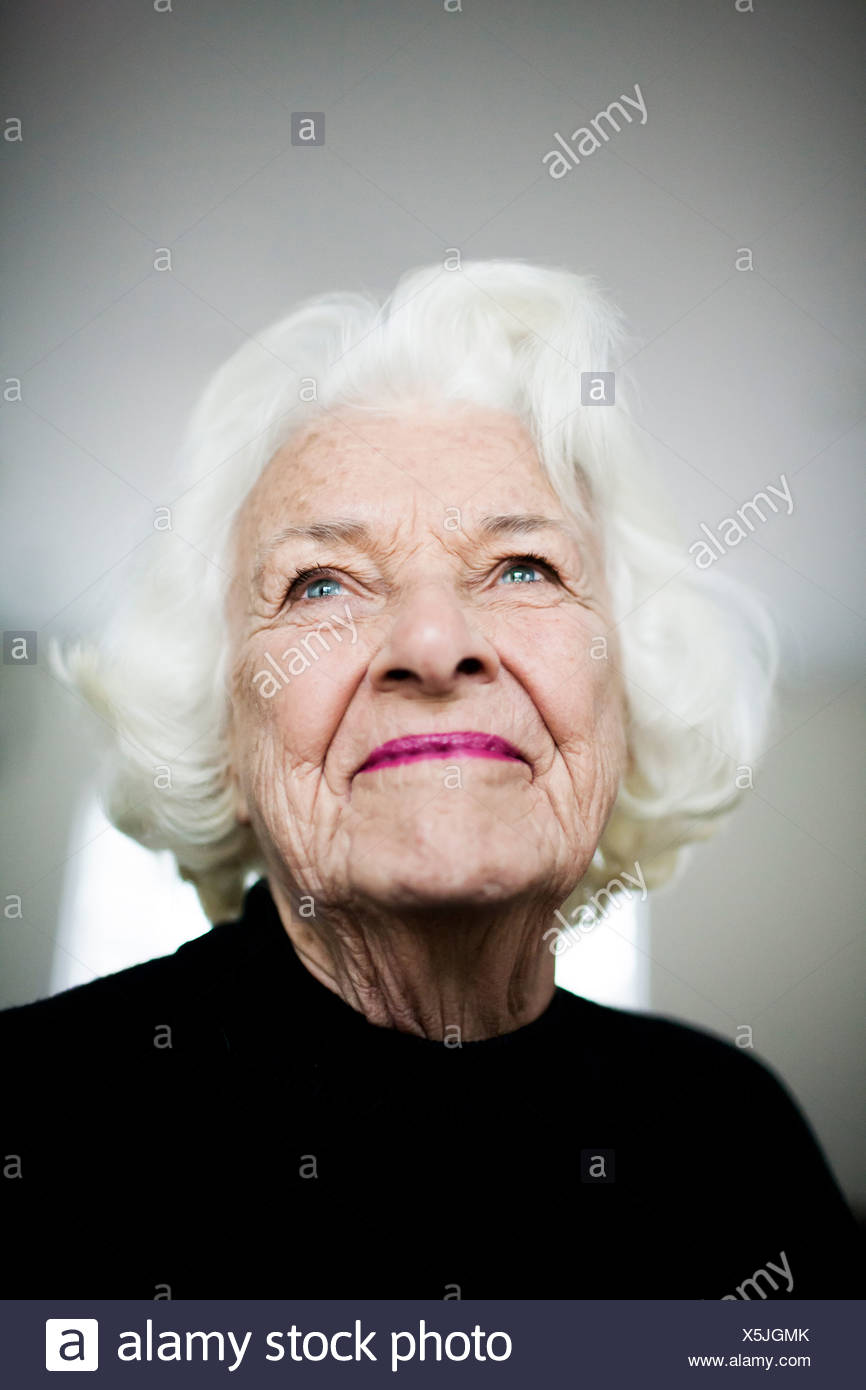 Portrait of senior woman looking up, studio shot Banque D'Images