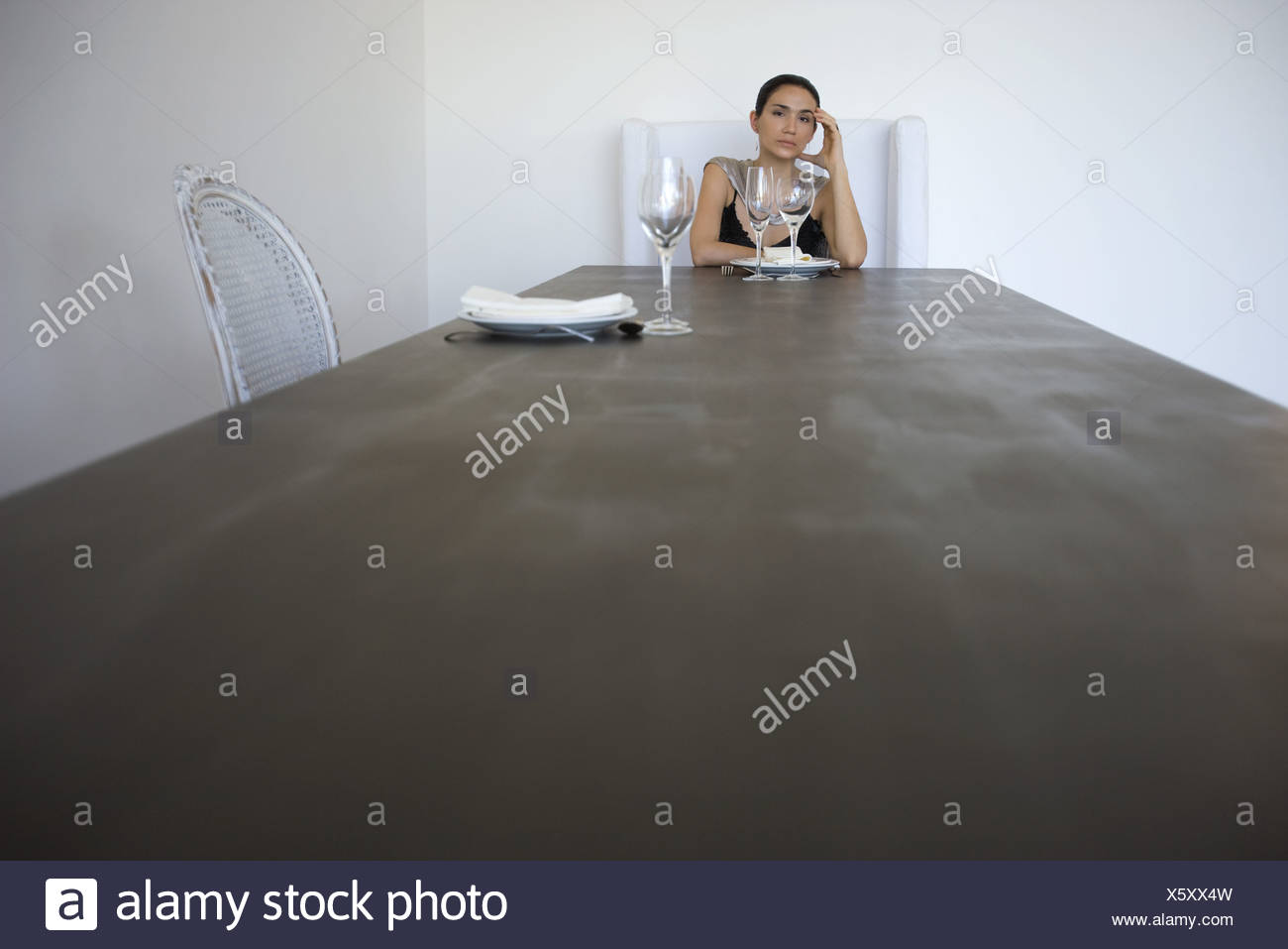 Femme assise seule à la table pour deux, holding head Banque D'Images