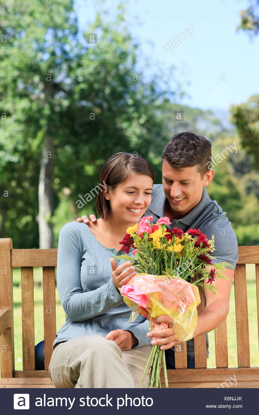 Jeune Homme Qui Offre Des Fleurs à Sa Petite Amie Banque D