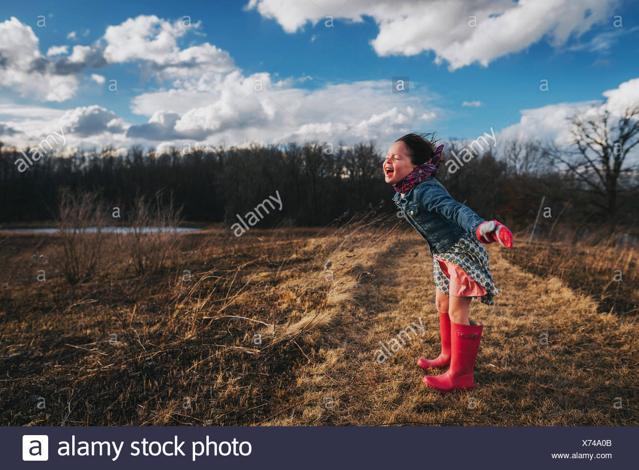 Girl with arms outstretched crier dans le vent Banque D'Images
