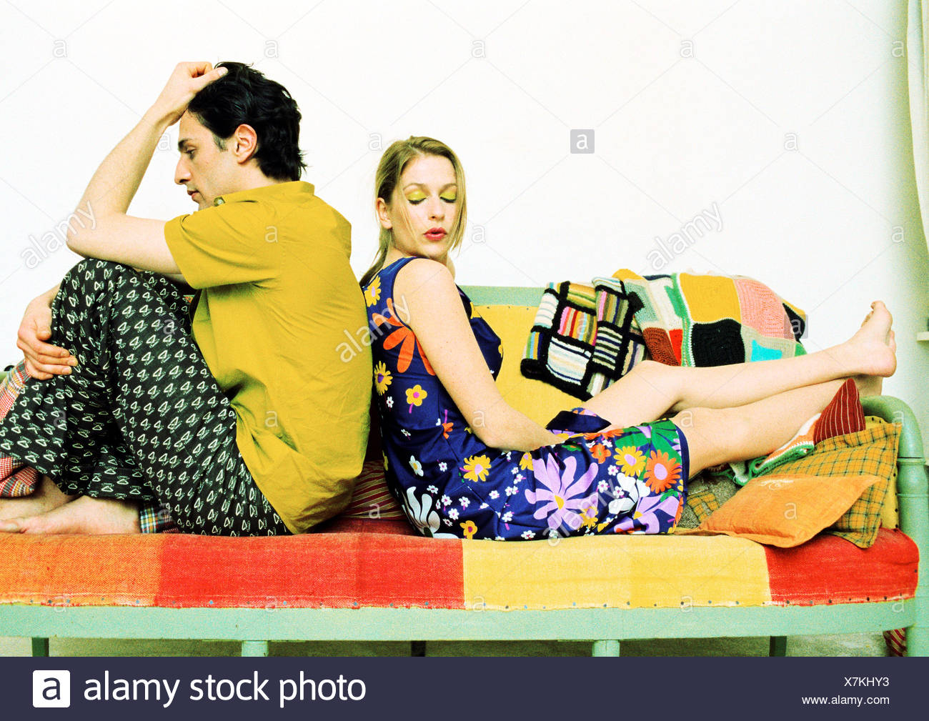 Couple assis sur le canapé, dos à dos. Banque D'Images