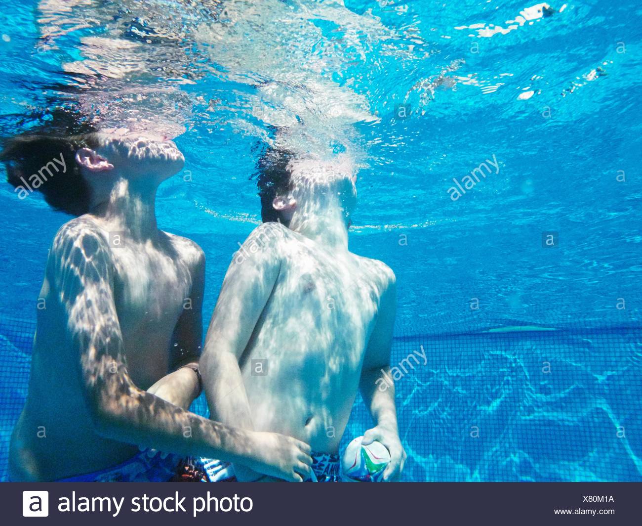 Sous-vue de deux garçons jouer au ballon en jeu piscine Banque D'Images
