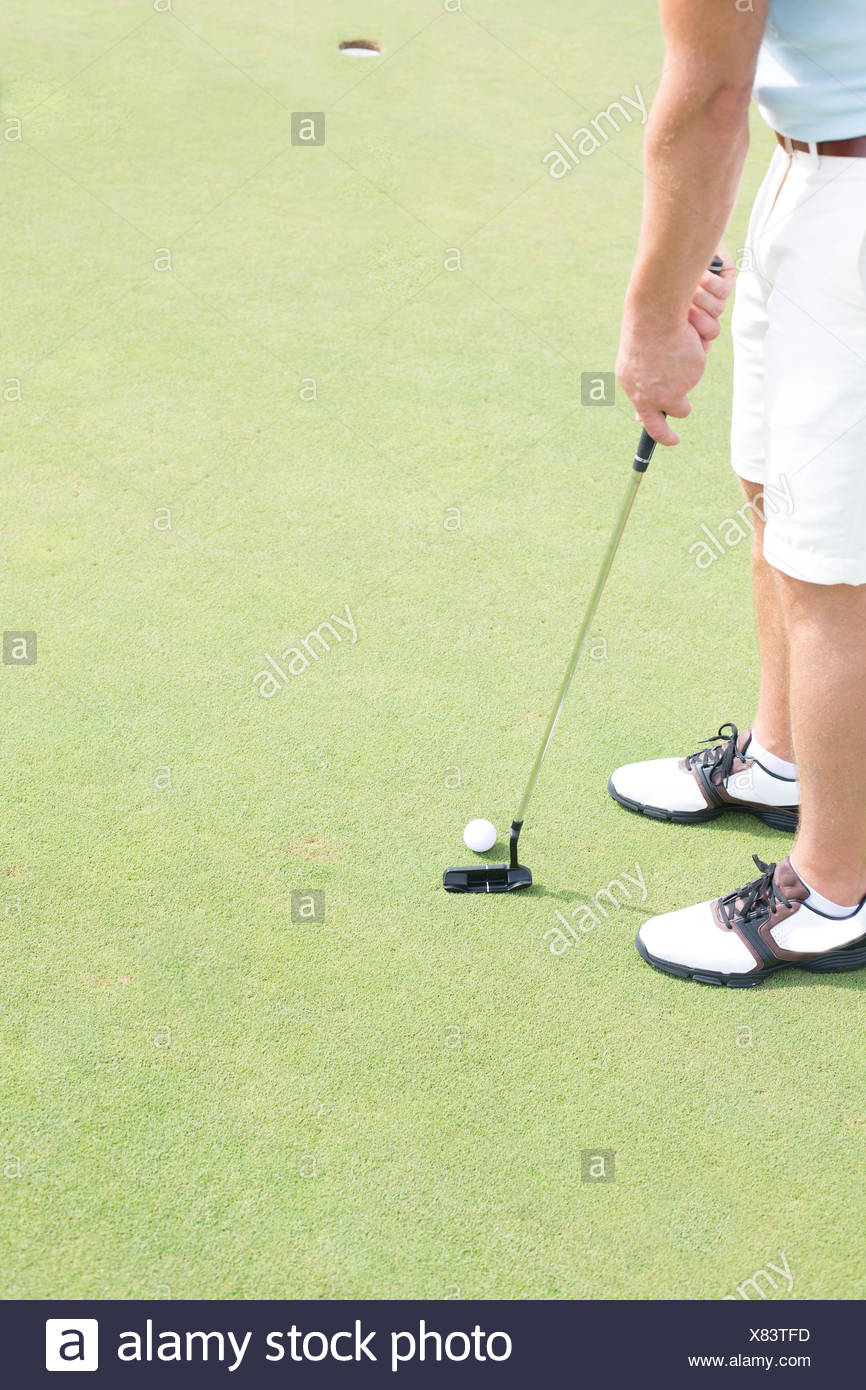 La section basse de mid-adult man playing golf Banque D'Images