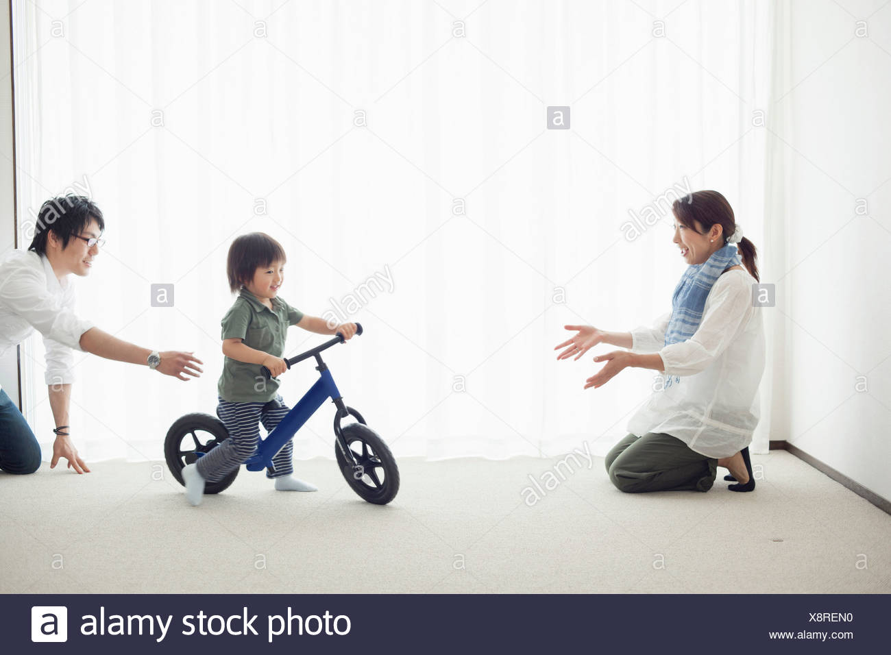 Les parents avec son fils à apprendre à faire du vélo location Banque D'Images