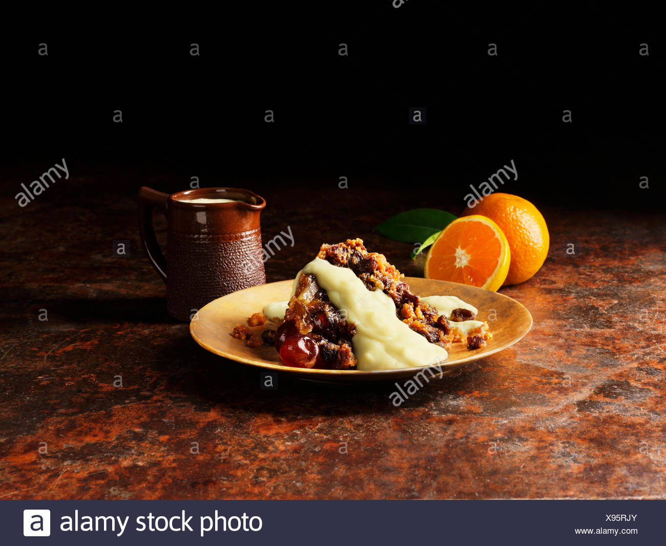 Le pudding de Noël avec la liqueur et sauce à l'orange sur la plaque d'or, les oranges, vintage pot de sauce Banque D'Images