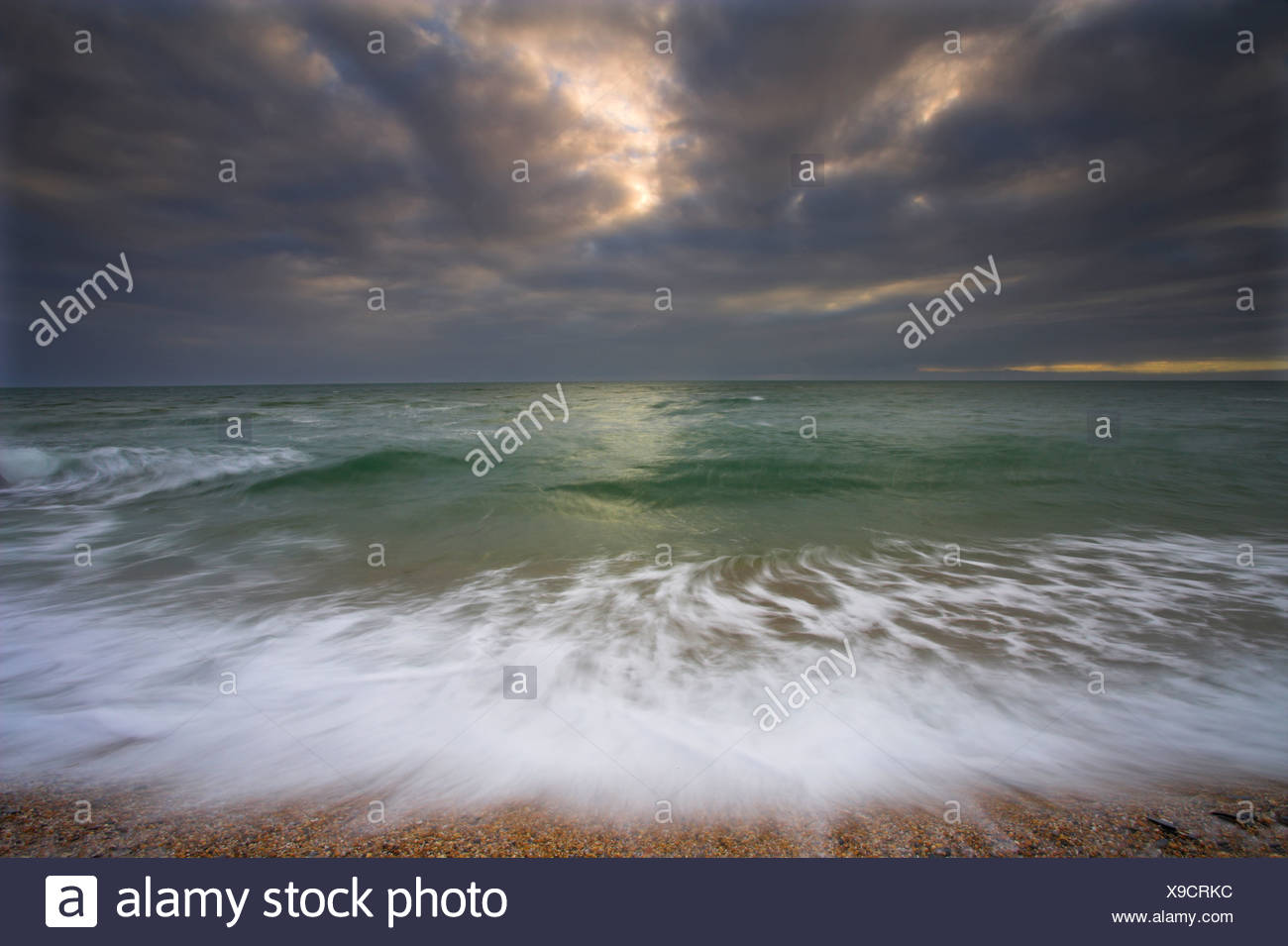 L'action des vagues et l'approche de l'orage. Lieu non identifié de sables bitumineux. Devon Banque D'Images