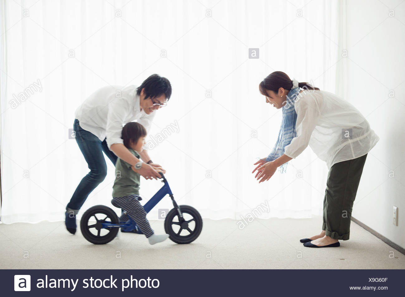 Les parents avec son fils à apprendre à faire du vélo location Banque D'Images