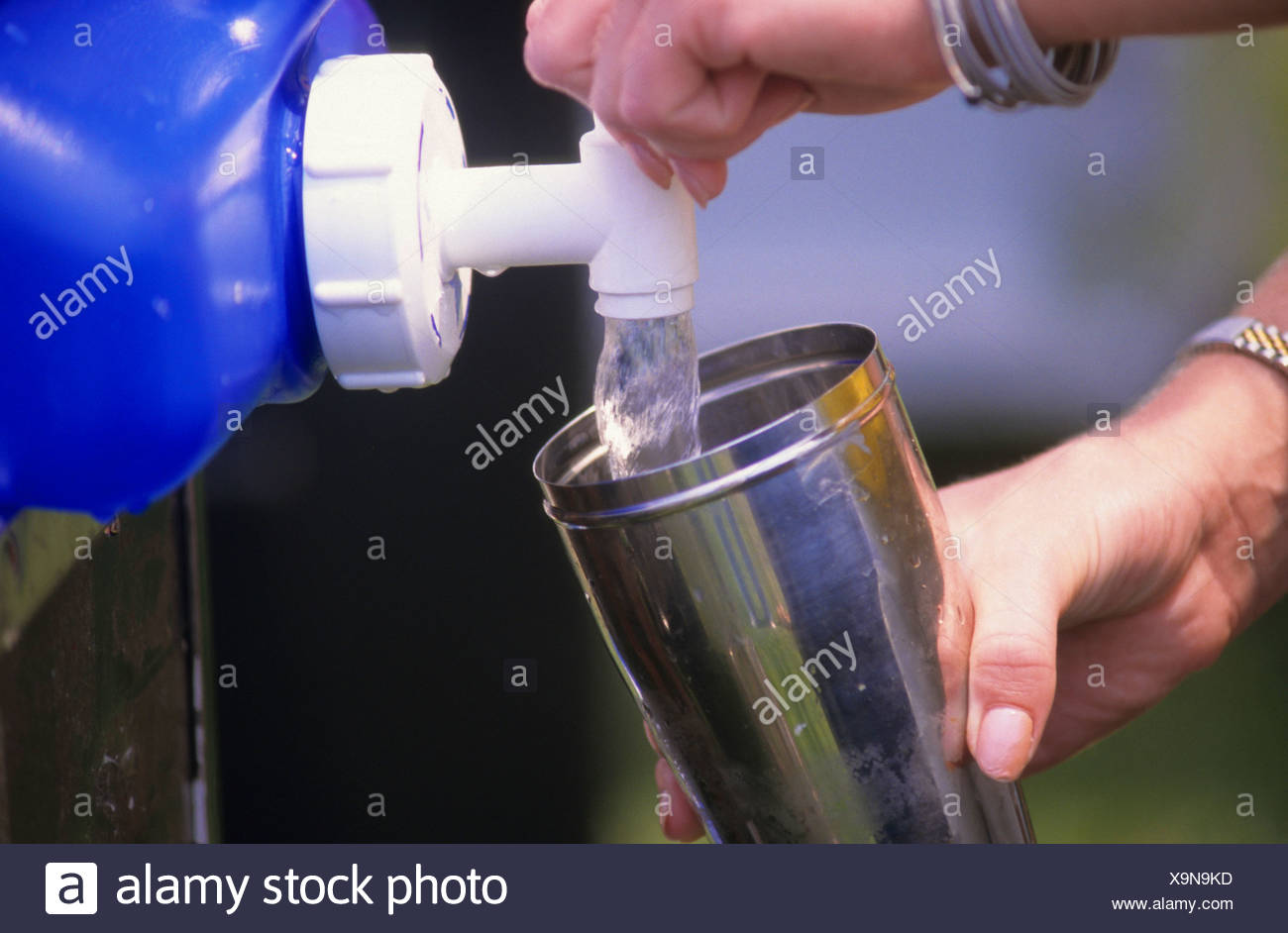 Verser de l'EAU DANS UNE TASSE DE LIMONADE STAND Banque D'Images