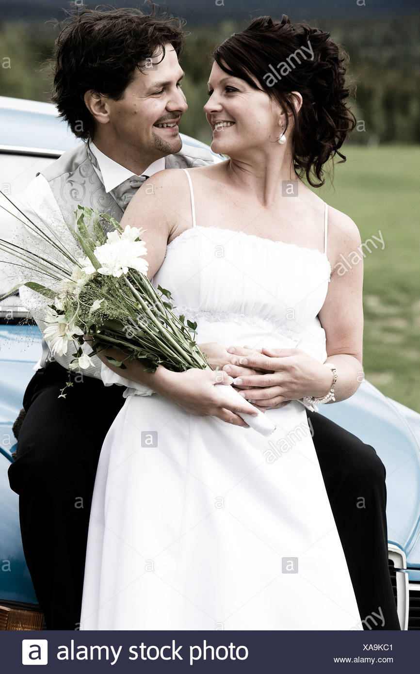 Heureux de Faire place au marié mariée de derrière comme ils regardent les uns les autres Banque D'Images