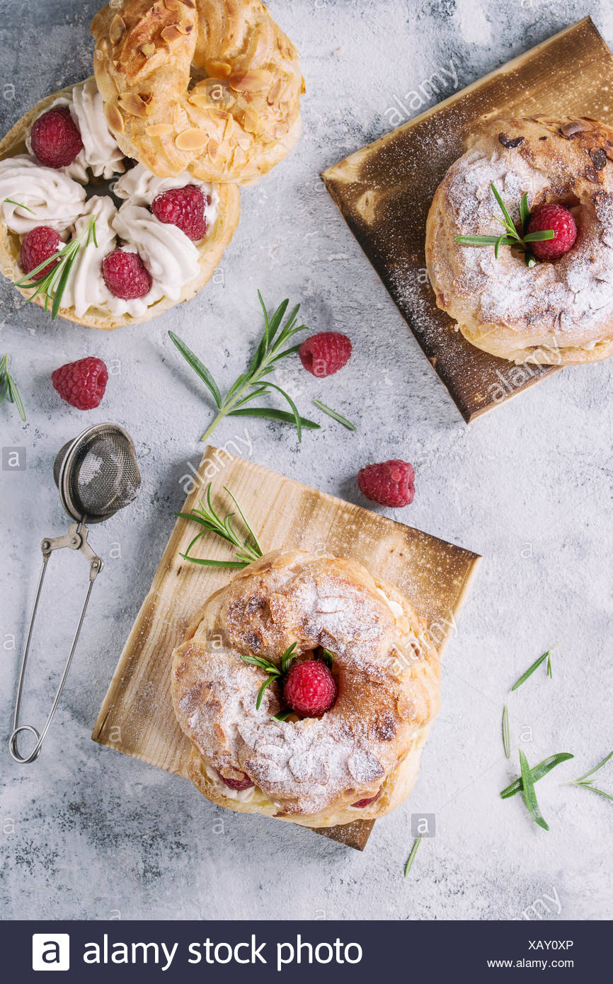 Gateau De Pate A Choux Maison Paris Brest Avec Des Framboises L Amande Le Sucre En Poudre Et Le Romarin Servi Sur Du Conseil En Plus De Texture Gris Bleu Retour Photo Stock Gateau De Pate A Choux Maison Paris Brest Avec Des Framboises L Amande Le Sucre En Poudre Et Le Romarin Servi Sur Du Conseil En Plus De Texture Gris Bleu Retour Photo Stock
